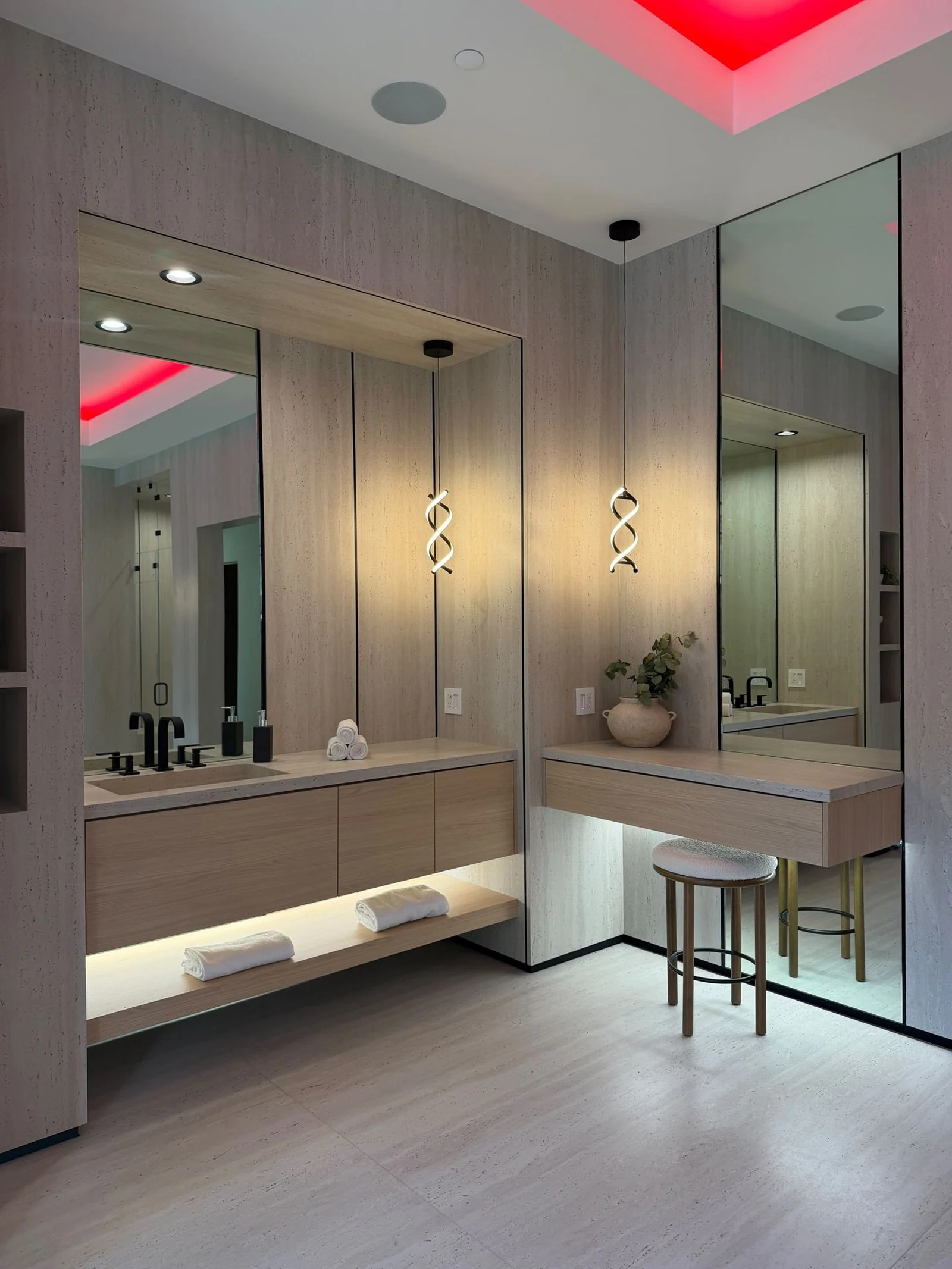 Vanity and dressing area with lit mirrors, a floating counter and a light plank floor